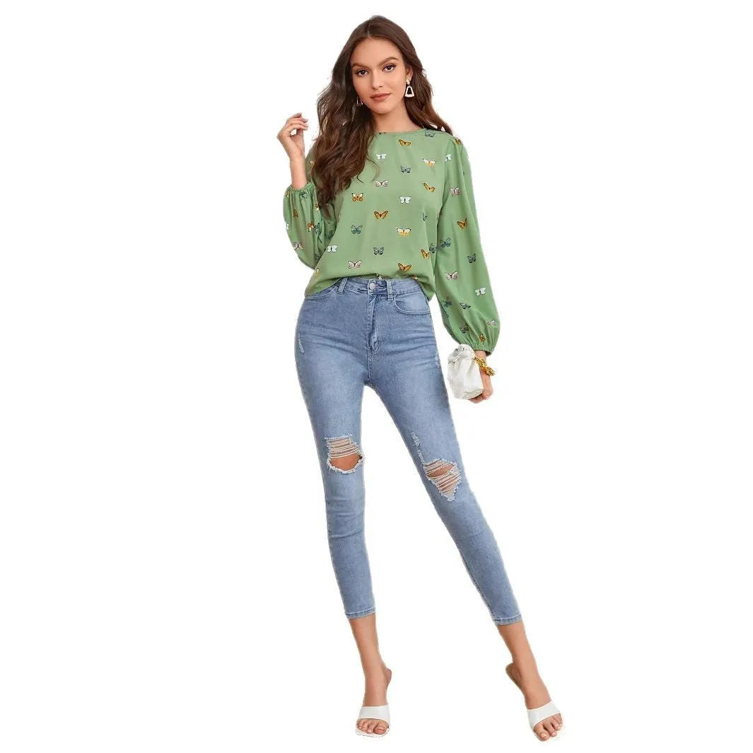 Women's green loose-fit long sleeve shirt with a colourful butterfly print.