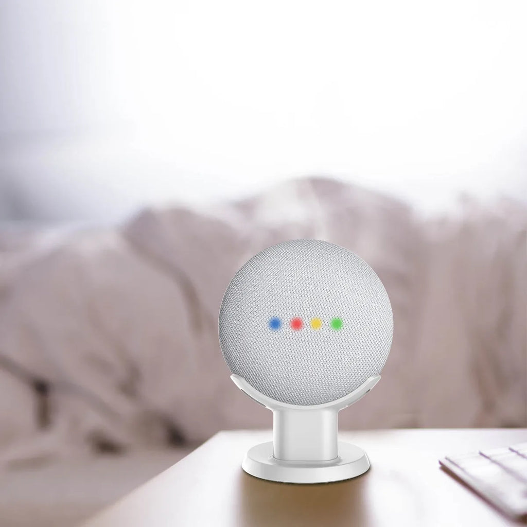 Black plastic stand holding a Google Home Mini smart speaker on a wooden table.