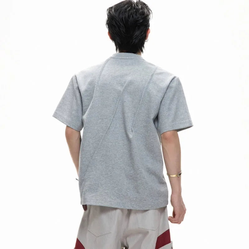 Man wearing a grey pleated cotton t-shirt with a round neck and loose fit.