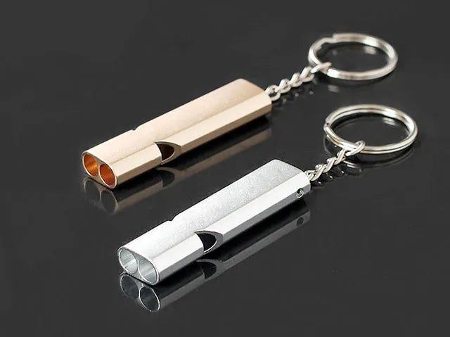 Gold and silver aluminium alloy double-hole survival whistle on a keyring.