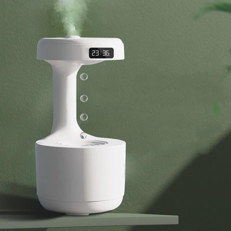 White anti-gravity humidifier with LED clock display emitting mist on a wooden desk.