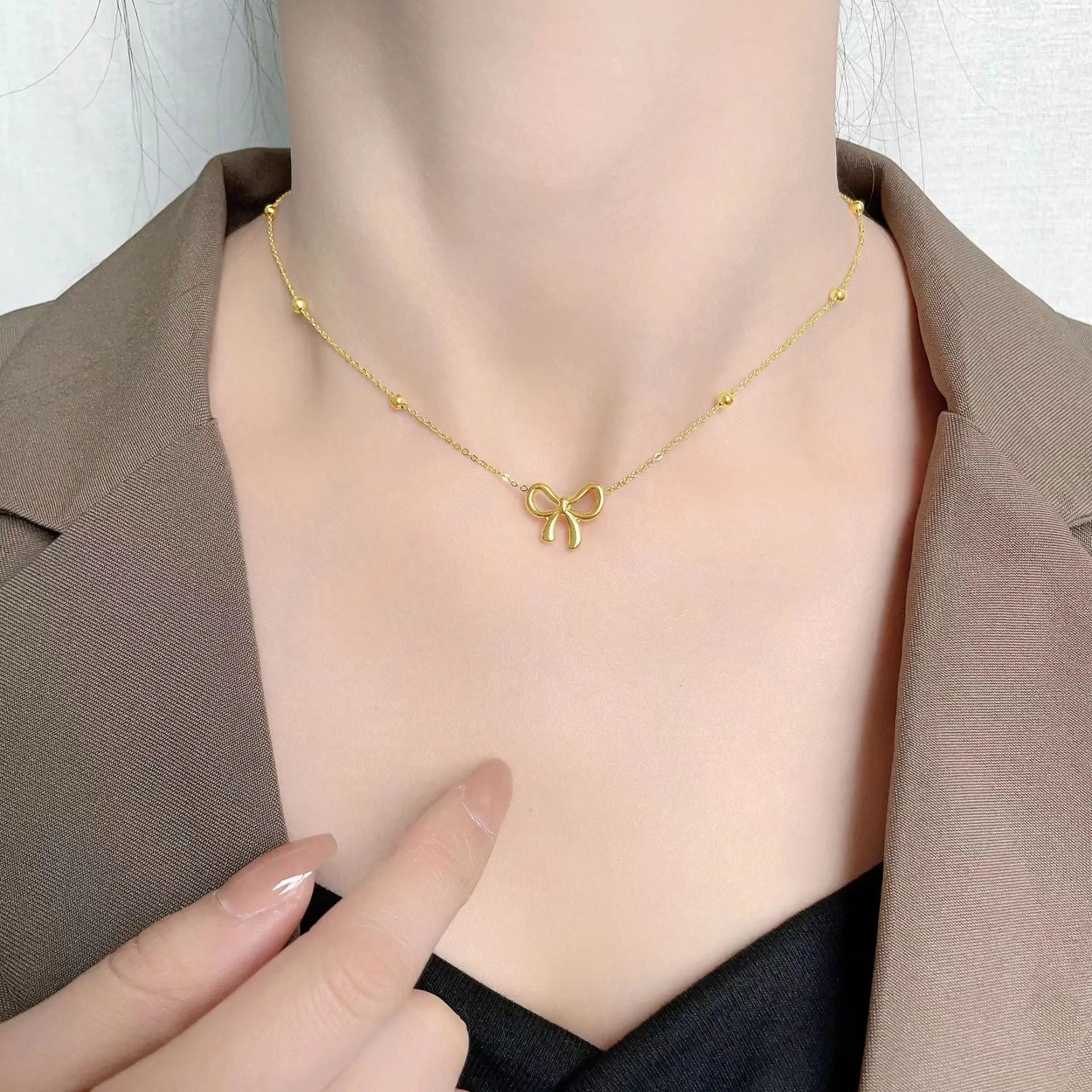 Gold electroplated bow necklace with adjustable 41-50cm length and cross chain