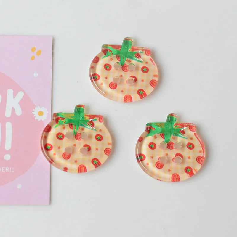 A pack of medium-sized plastic tomato button ornaments in mixed colours including red plaid and cherry tomato print.