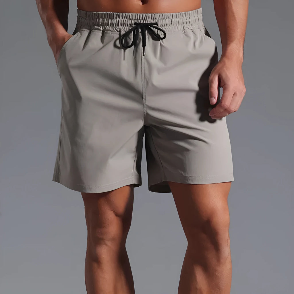 Man wearing loose-fitting khaki casual shorts made from quick-dry polyester fabric.