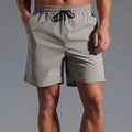 Man wearing loose-fitting khaki casual shorts made from quick-dry polyester fabric.