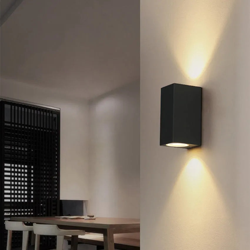 Modern aluminium LED wall lamp in a black finish mounted on a wall.