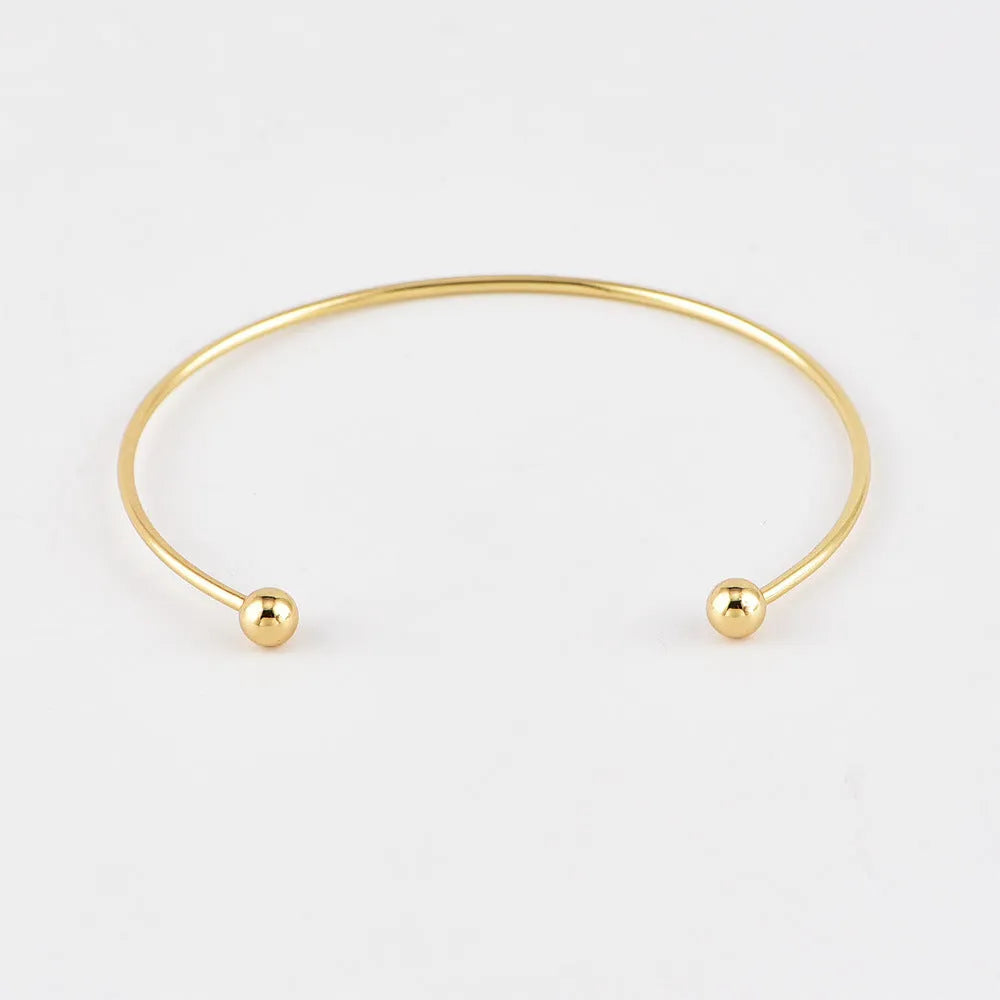 Gold alloy geometric bangle combination set with electroplated finish and about 16cm diameter