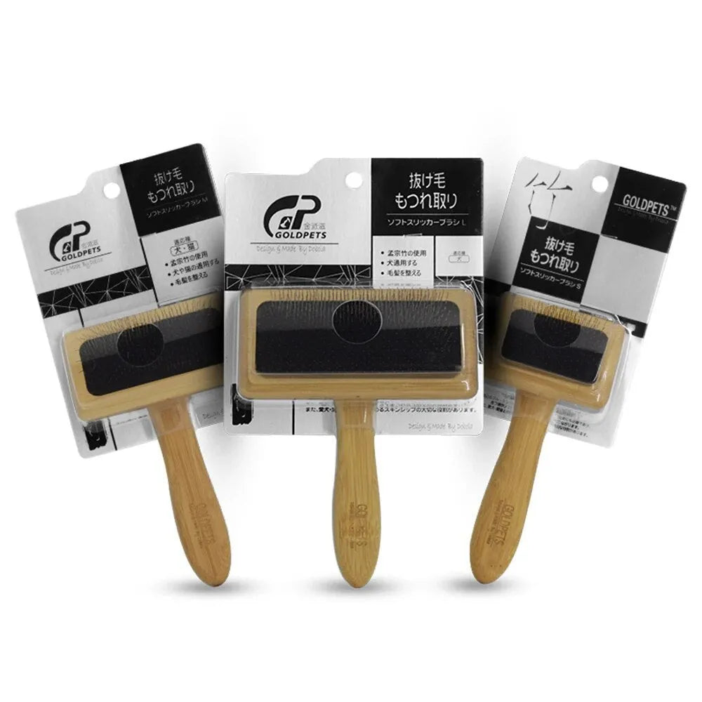 Goldpets bamboo and wood pet slicker brush with stainless steel pins on a wooden table.
