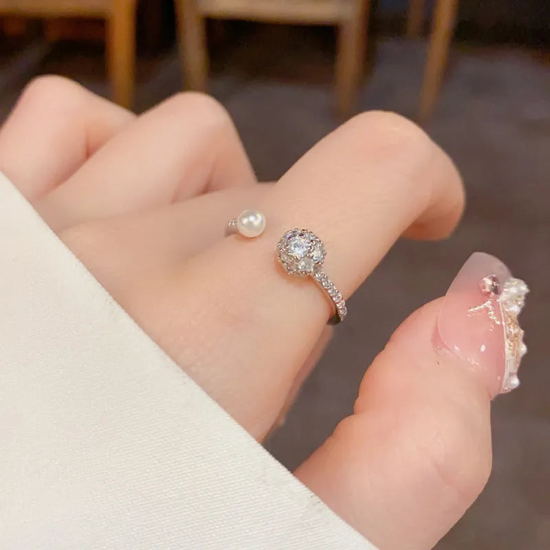Gold or silver open-end pearl ring with round zircon detailing on a geometric band.