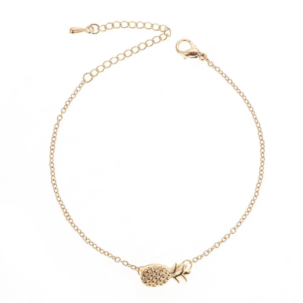Gold or silver tone alloy bracelet with a central pineapple charm on a model's wrist.