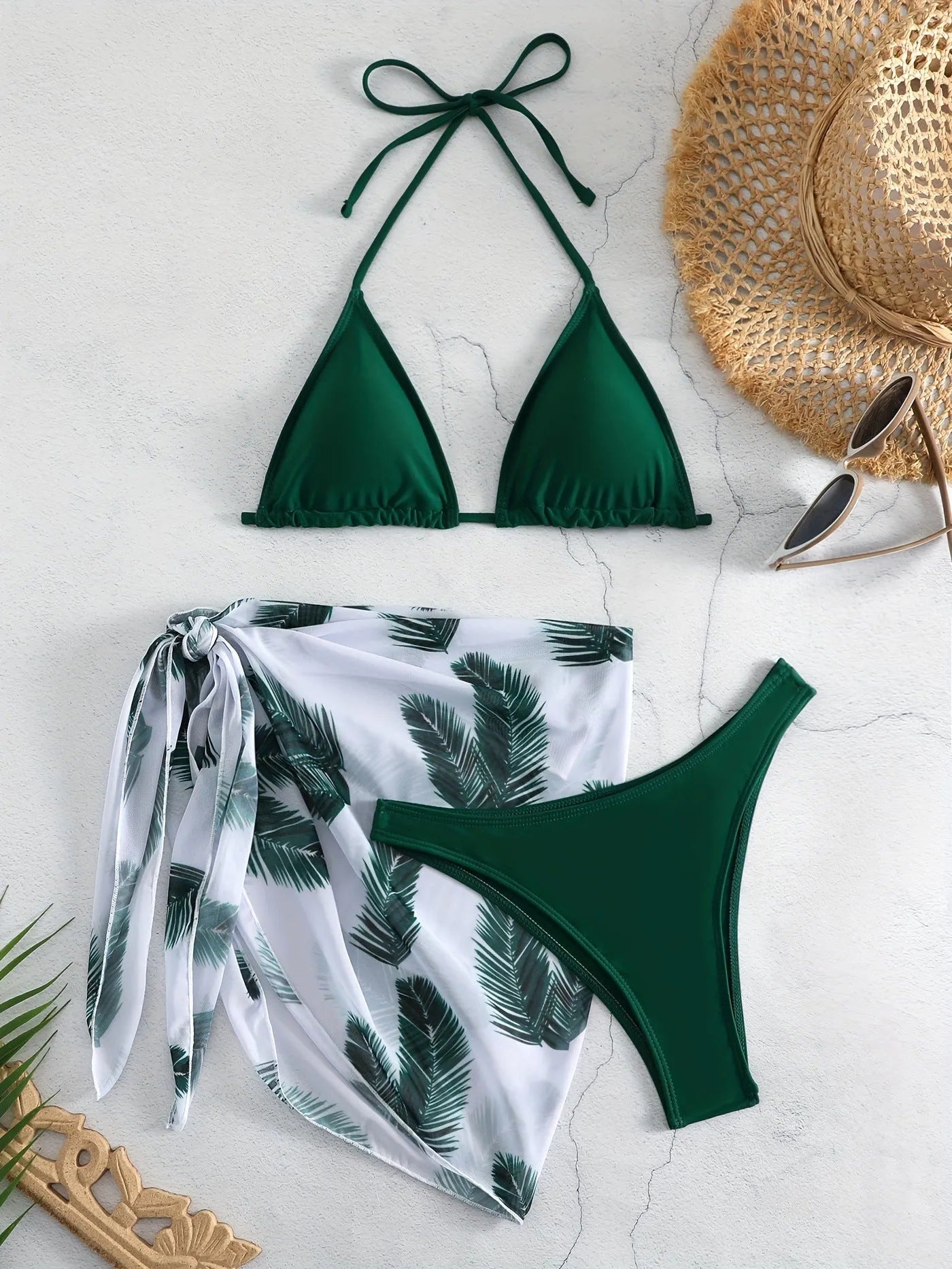 Orange three-piece bikini swimsuit set with a matching printed gauze skirt laid flat.