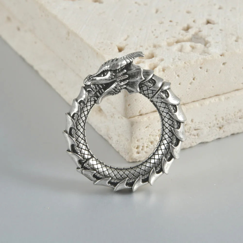 Large antique silver dragon-shaped earrings with hollow-out geometric design.