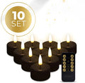 Four black LED tealight candles showing flickering light effect on a table.