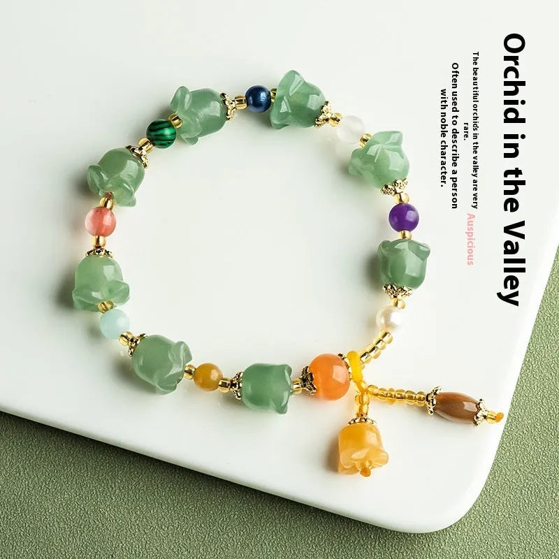 Natural Xinjiang Jinsi Jade bracelet with carved aventurine orchid beads on a wrist.