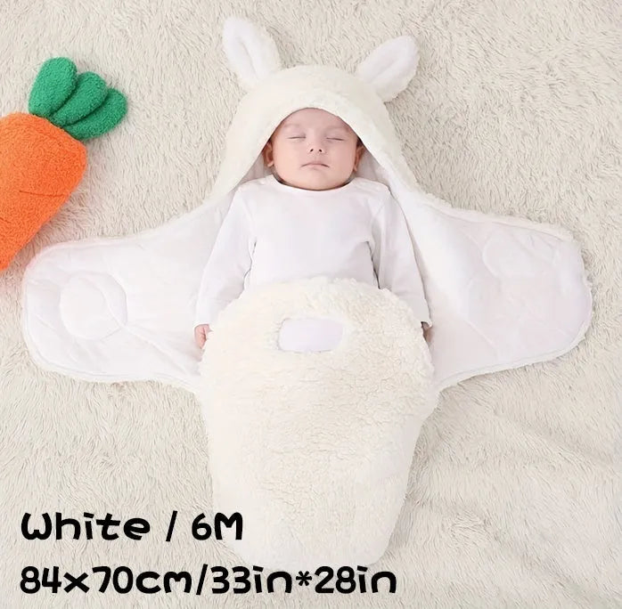 A baby wearing a soft grey fleece sleeping bag with hook-and-loop shoulder straps.