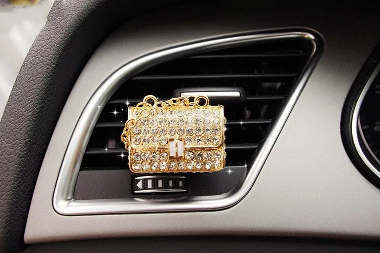 Alloy car fragrance clip with decorative charm attached to car air vent