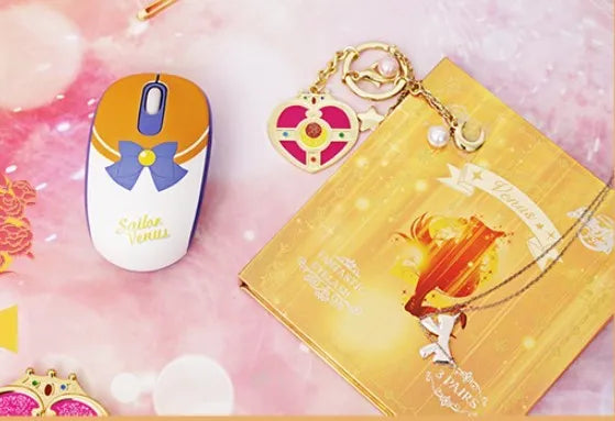 Pink Sailor Moon cartoon character wireless mouse on a desk next to a laptop.