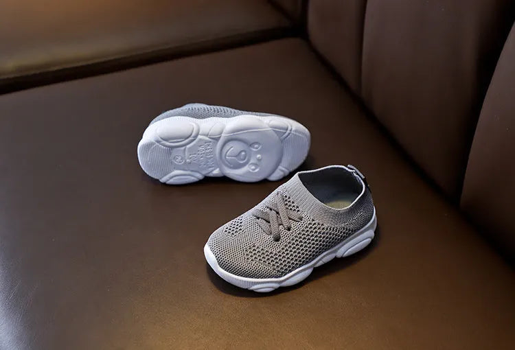 Children's white lazy slip-on shoe with fabric upper and textured non-slip rubber sole.