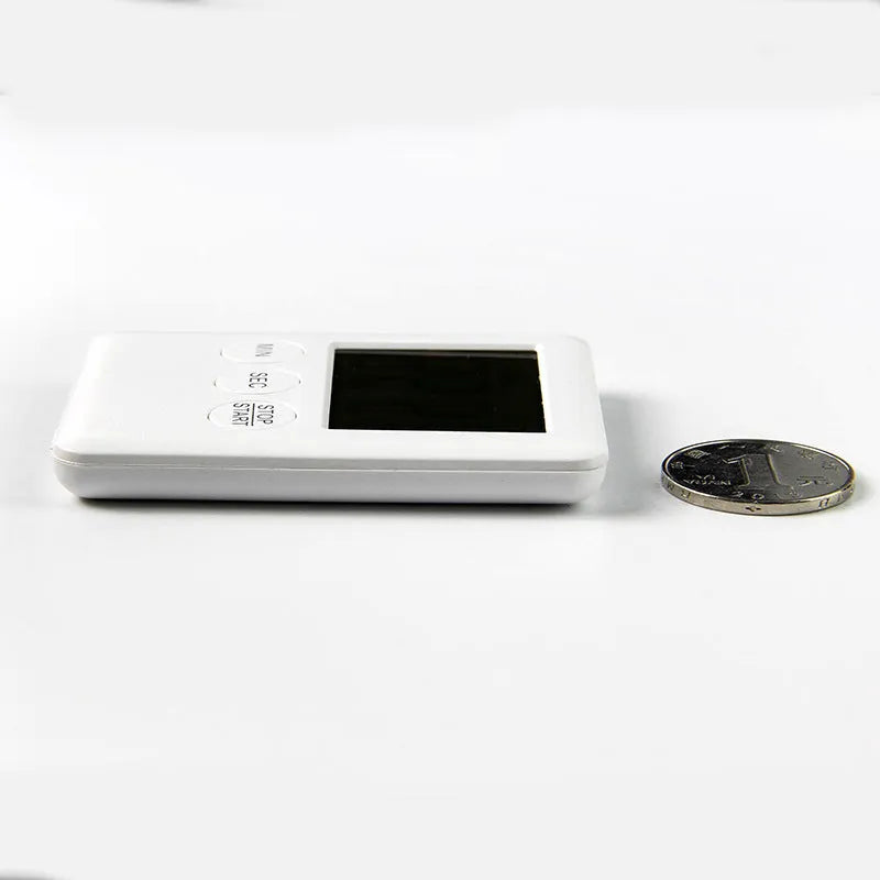 Black and white magnetic kitchen timer with large 5.5cm clock face on a steel fridge door.