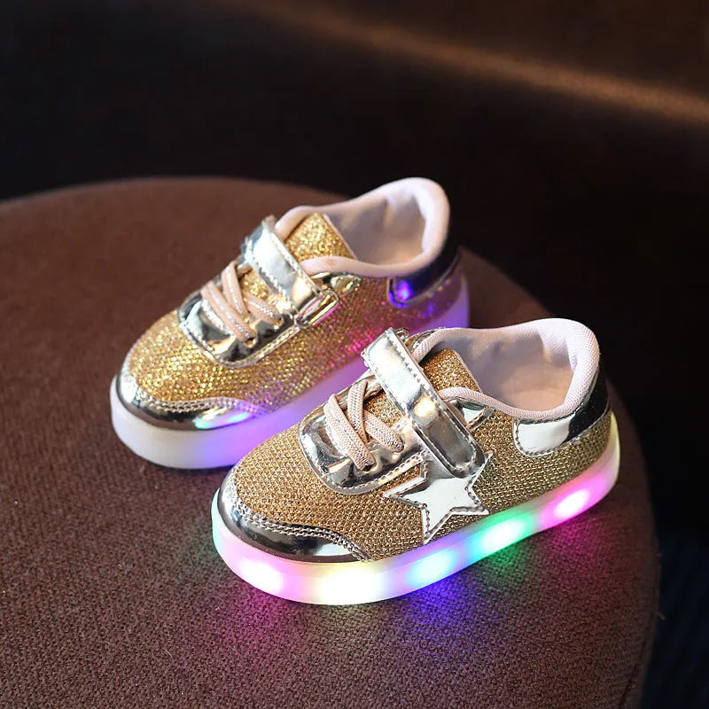 Children's LED light-up trainers with glowing rainbow soles in golden, pink and silvery colours