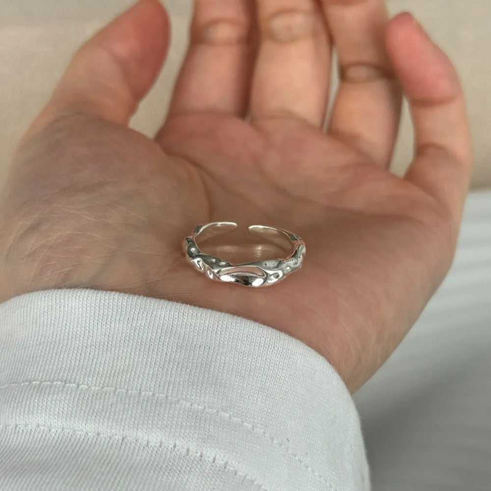 Irregular silver opening adjustable ring for women with electroplated finish on plain background