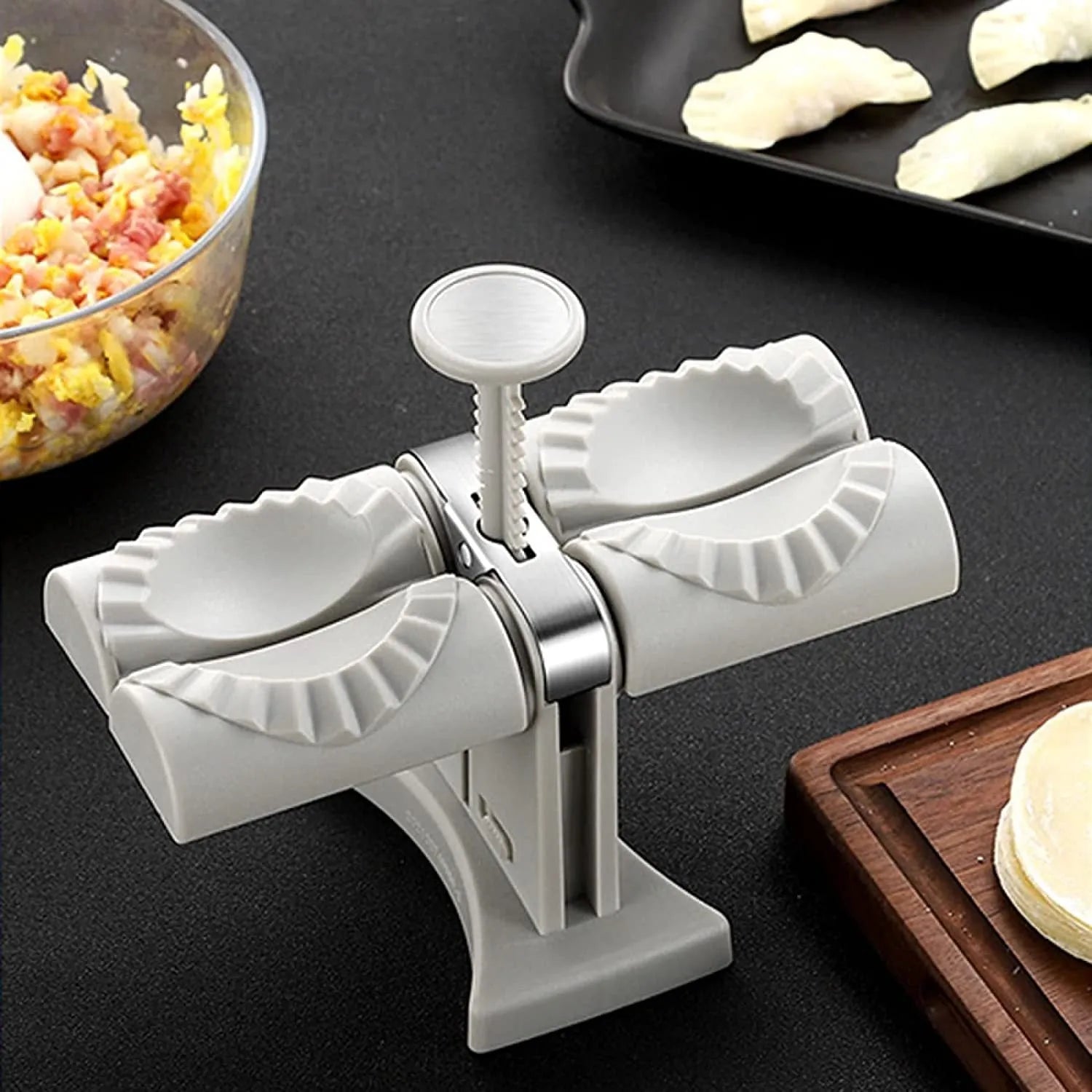 White double head manual dumpling press mould with anti-slip rubber base on kitchen counter.