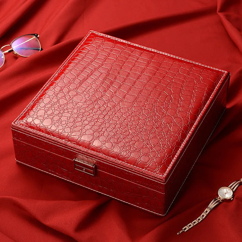 Green fashion leather double layer jewellery storage box with lock on wood.