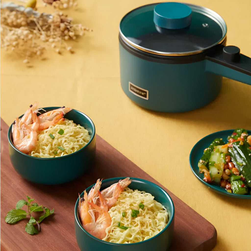 Nordic green mini electric pot with lid and steamer on countertop