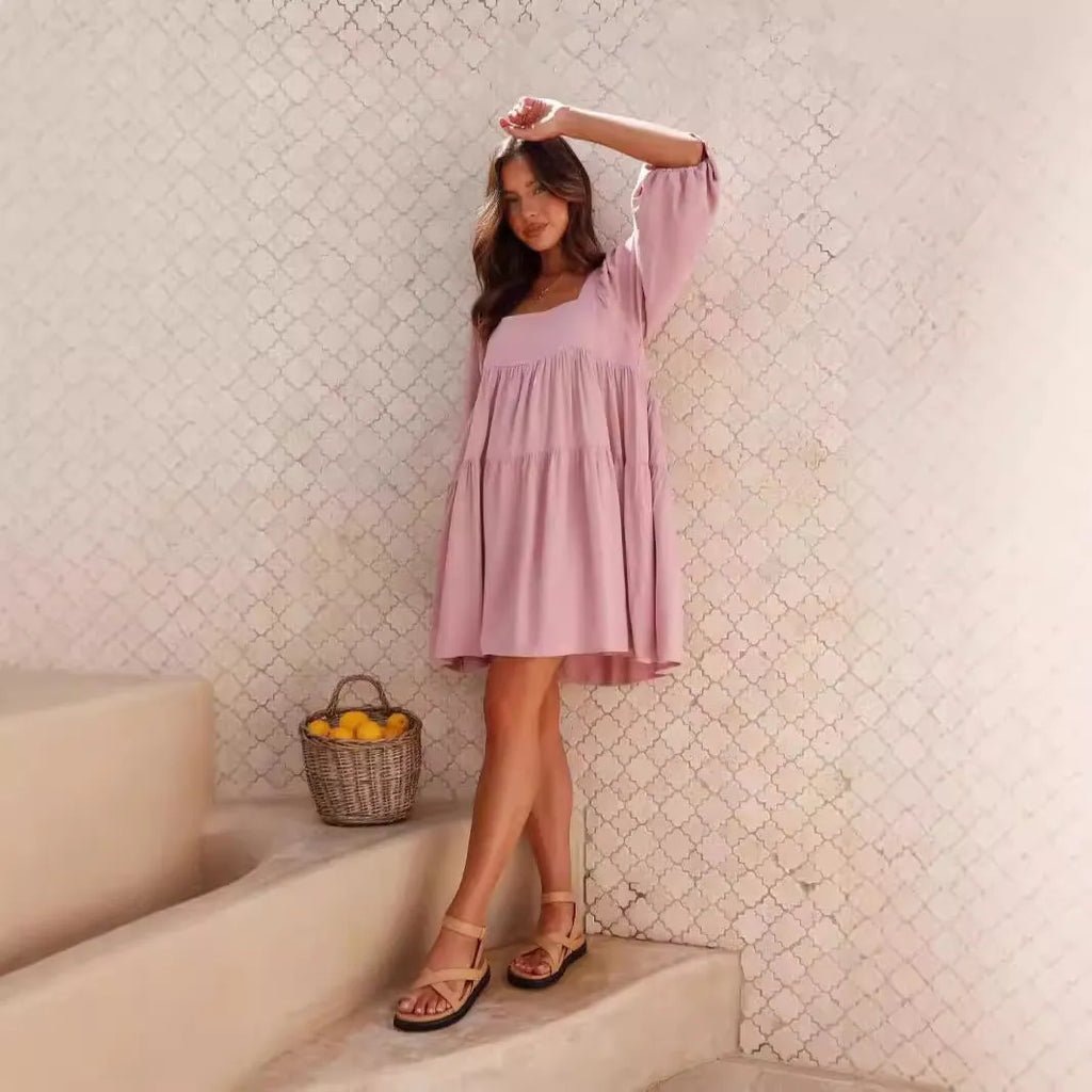 A light blue children's backless dress with a square collar, puff sleeves, and an A-line skirt on a hanger.