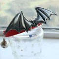Black patent leather dog collar with red devil wings and a small silver bell attached.