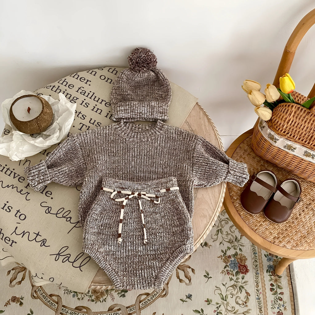 Dark brown knitted baby girl three-piece set with removable fur ball hat, blouse, and shorts
