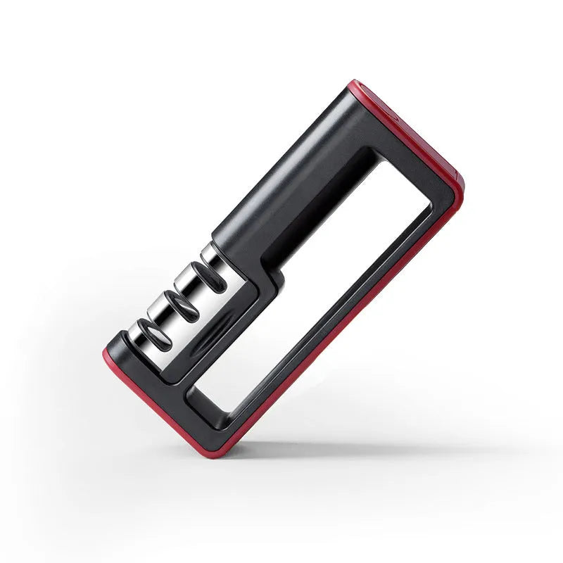 Professional three-stage knife sharpener in black with red trim, showing coarse, ceramic and fine abrasive slots.