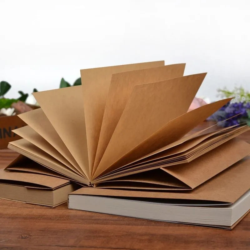 Brown and white kraft paper sketchbooks showing 16K and 32K sizes open to reveal drawing pages