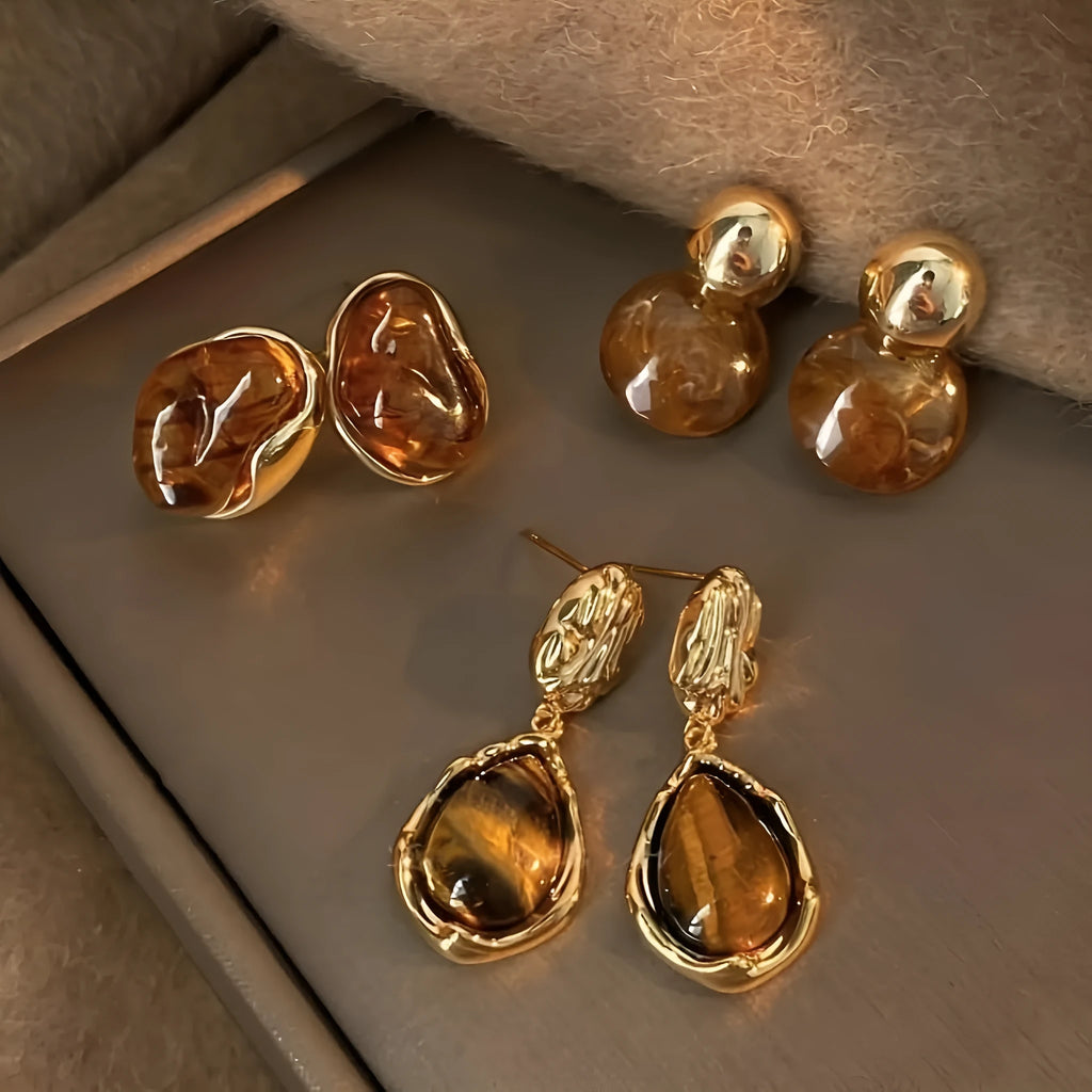 Set of three geometric alloy earrings with tassel detailing in gold, amber and tiger eye colours