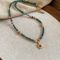 Freshwater pearl necklace with a blue stone sun pendant on an adjustable gold-toned chain.