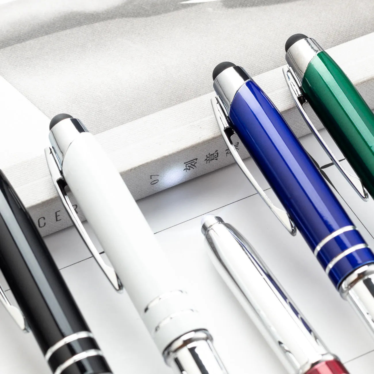 Multifunctional metal ballpoint pen with capacitive stylus tip and LED light in red, black, white, green, and blue colour options.