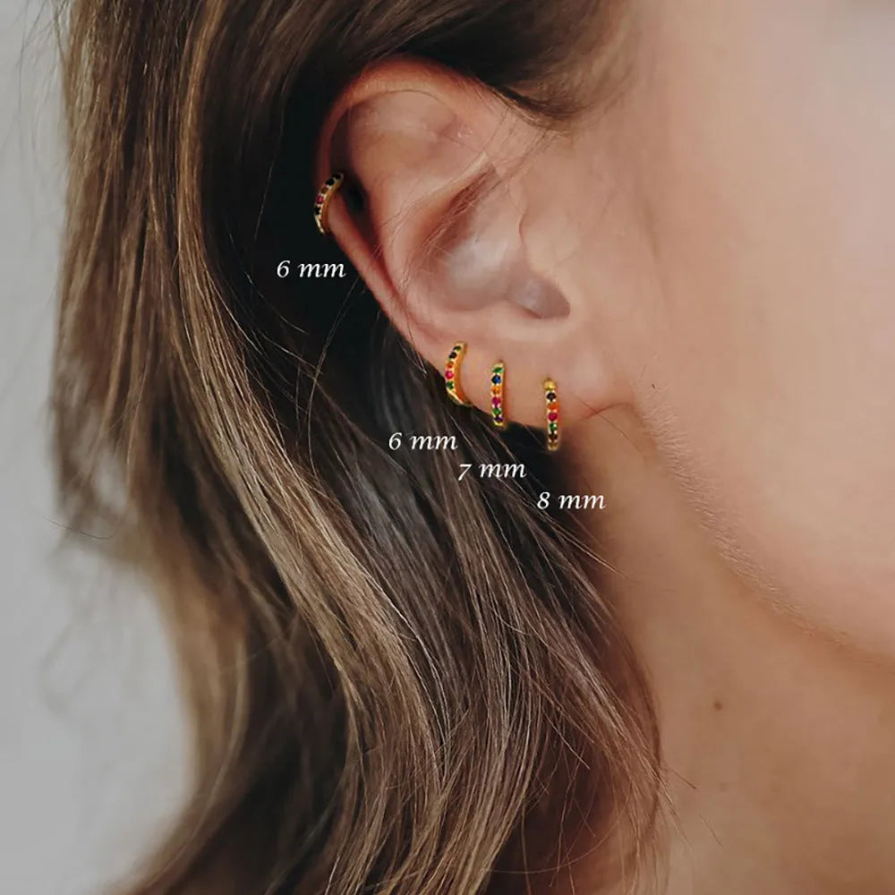 Circle zircon perforated stud earrings in gold, rose gold, and silver colour on a card.