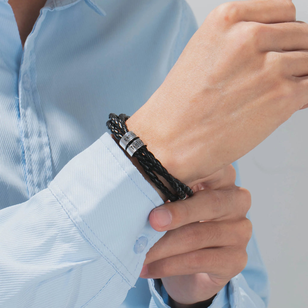 Personalised mens braided genuine leather bracelet in black with custom stainless steel name beads showing engraved names