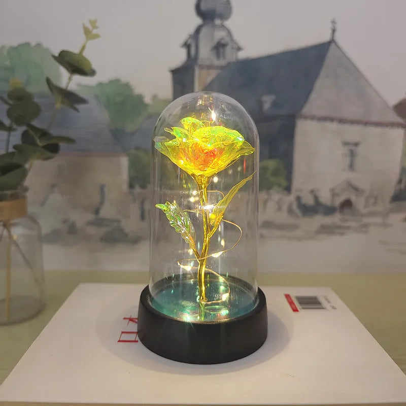 Small plastic night lamp with glass-style cover and decorative flowers, showing coloured LED light options.