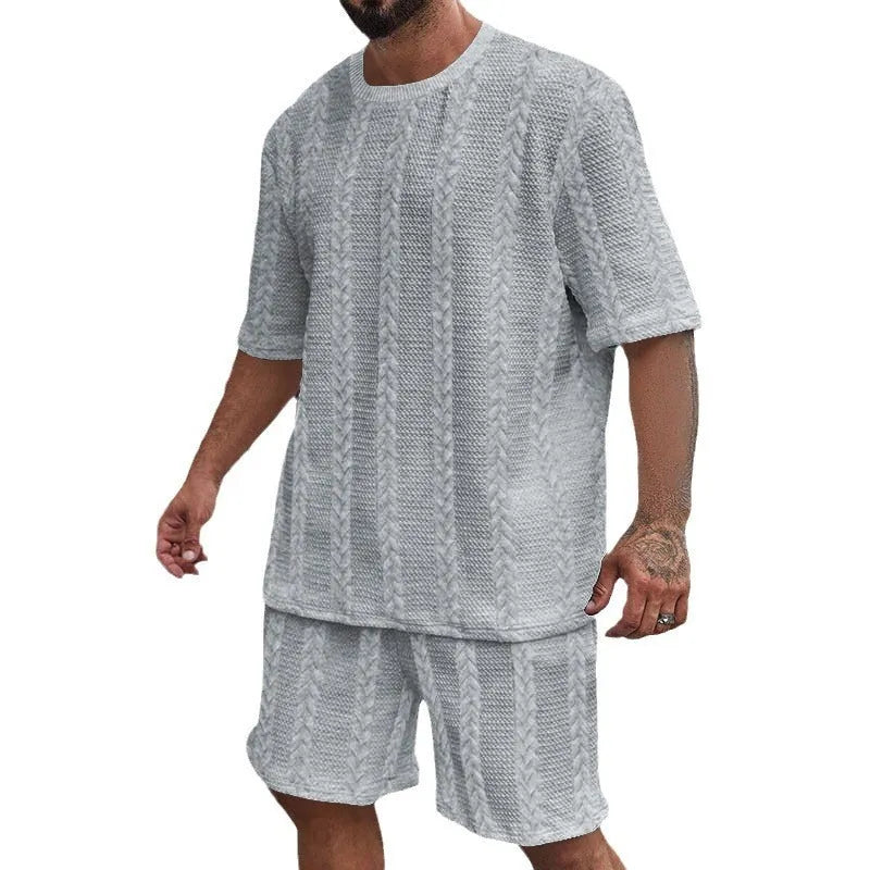 Knitted solid colour short sleeve pullover and matching shorts laid flat.