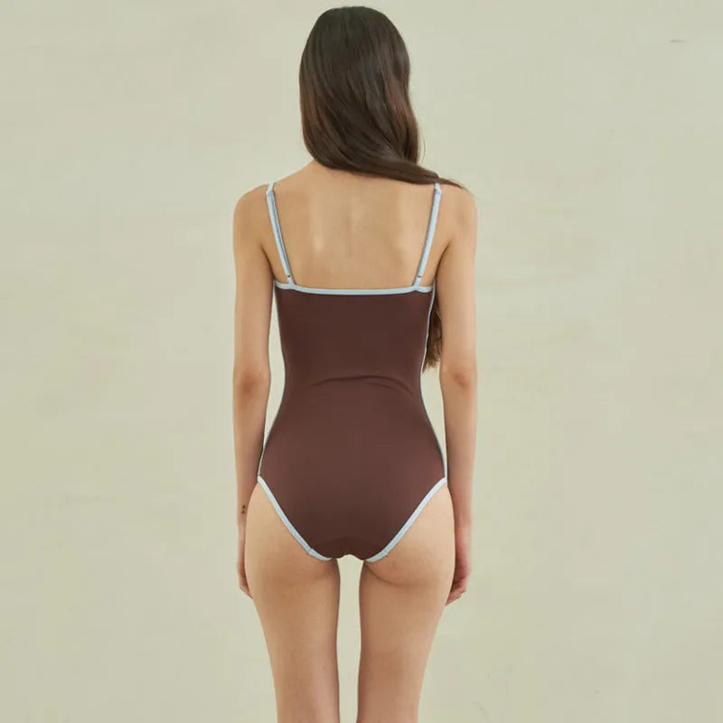 Brown triangle one-piece swimsuit for women on a mannequin, showing front design.