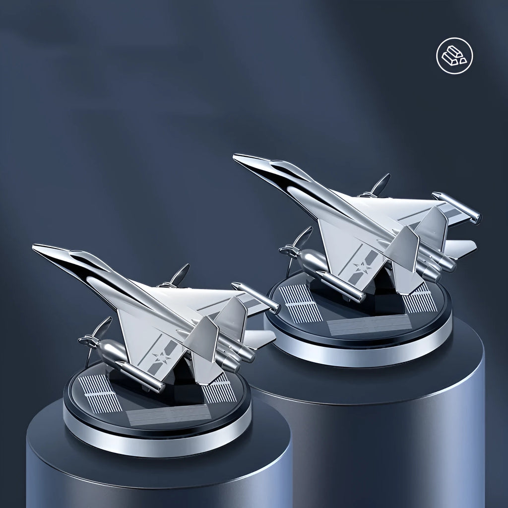 Silver solar-powered rotating fighter jet perfume ornament on a surface.