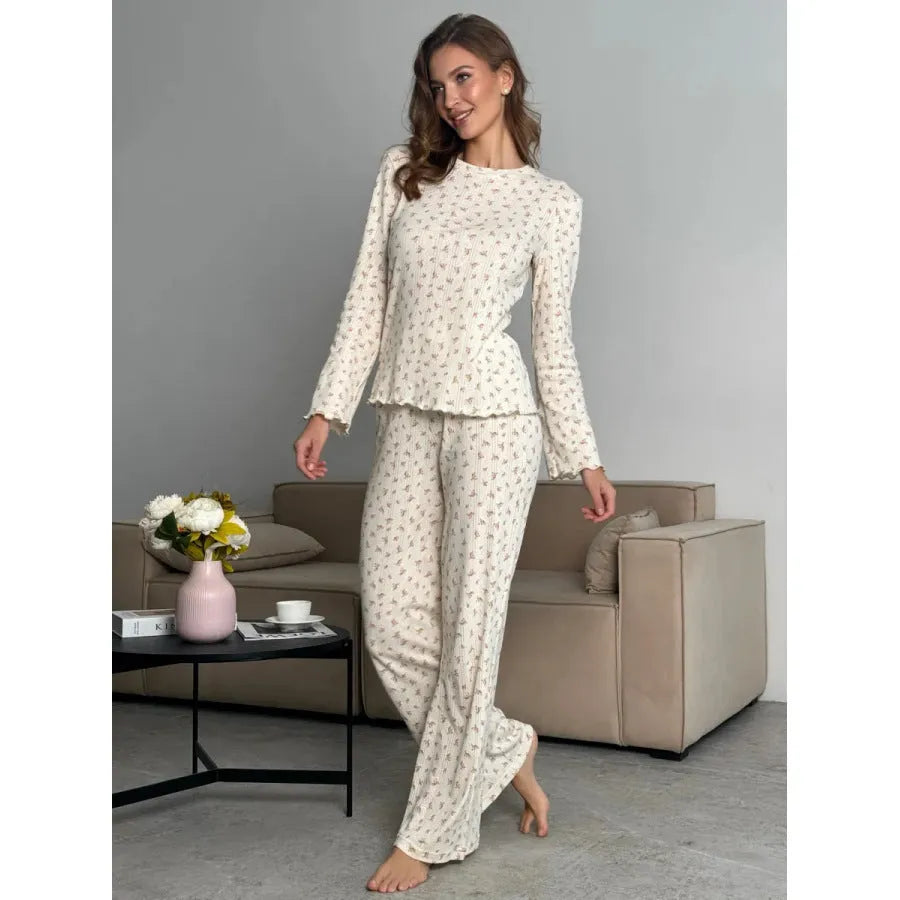White floral print women's suit with bell sleeve top and wide-leg trousers laid flat