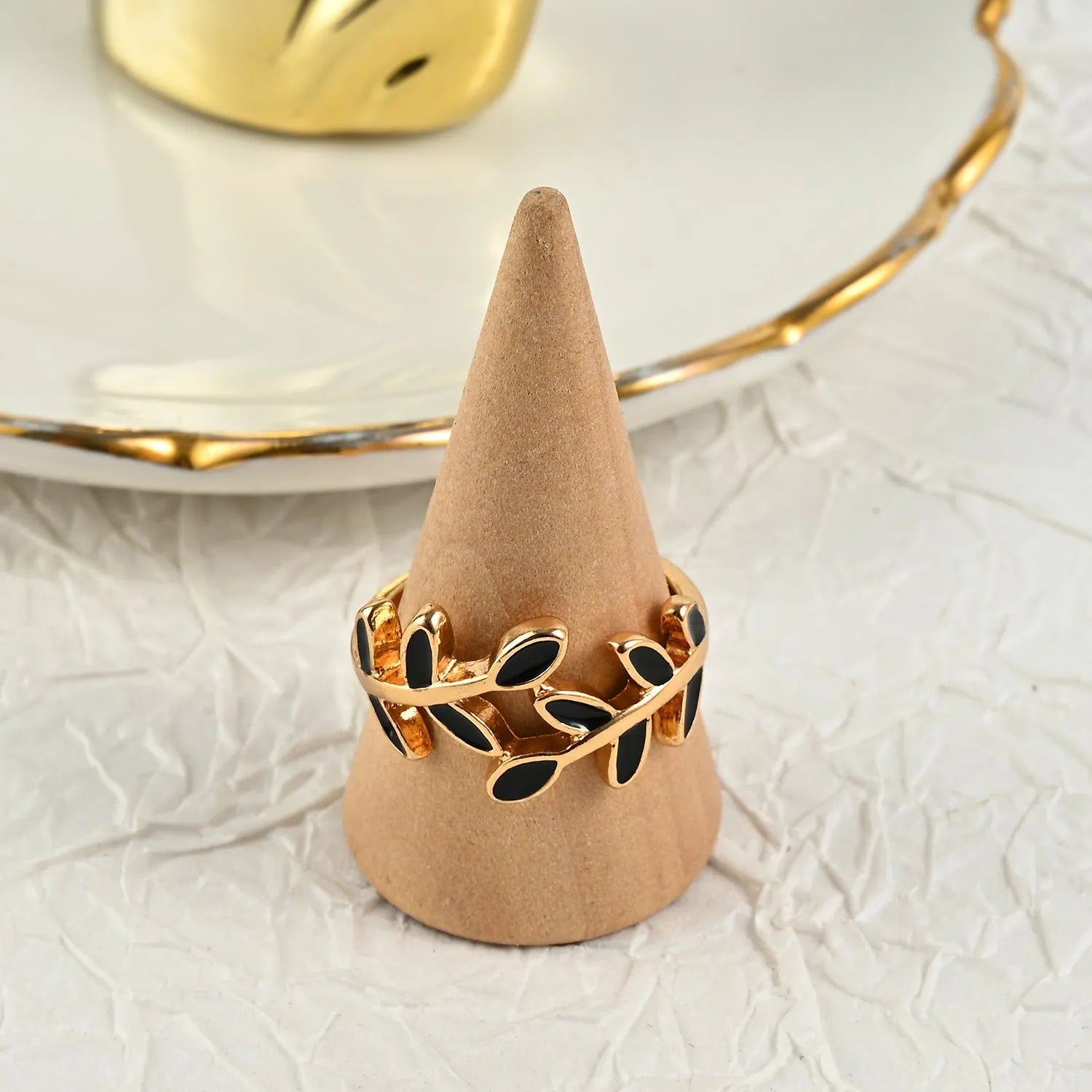 Gold geometric leaf and flower shape acrylic ring for women on index finger.
