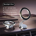 Vacuum magnetic suction phone bracket in black on car dashboard holding a smartphone
