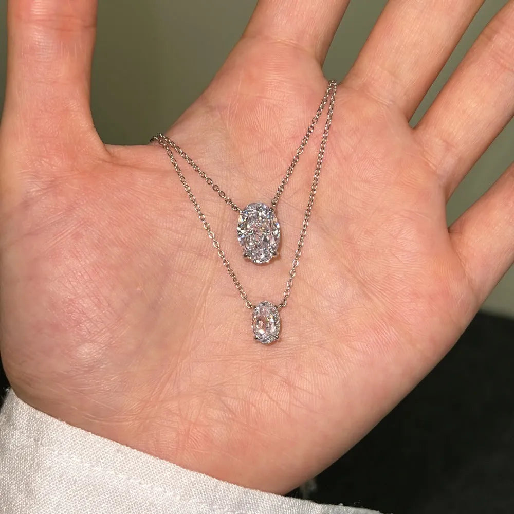 Close-up of a women's oval ice flower pendant sterling silver necklace on a chain.