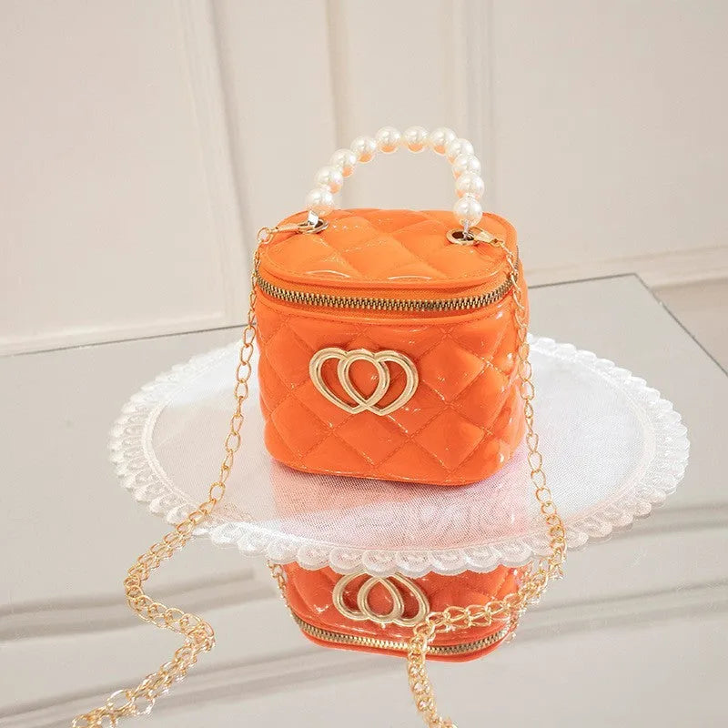 White PVC bucket bag with a red heart pattern, showing its shape and design.