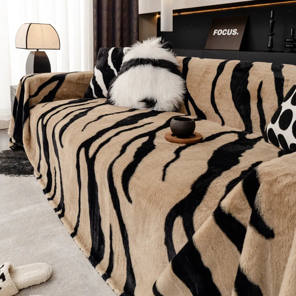 Zebra pattern flannel sofa cover draped over a sofa, showing non-slip underside and matching pillowcase.