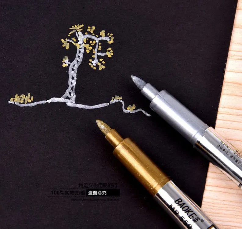 Gold and silver metallic marker pens on a white background