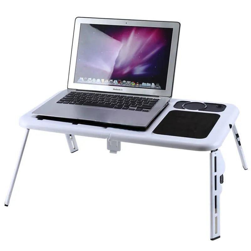 White folding computer desk bed with adjustable legs and tilting baseplate, open on a bed showing dual heat vents